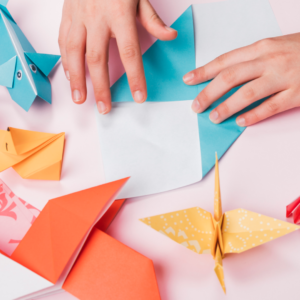 A female is making origami by folding using hands